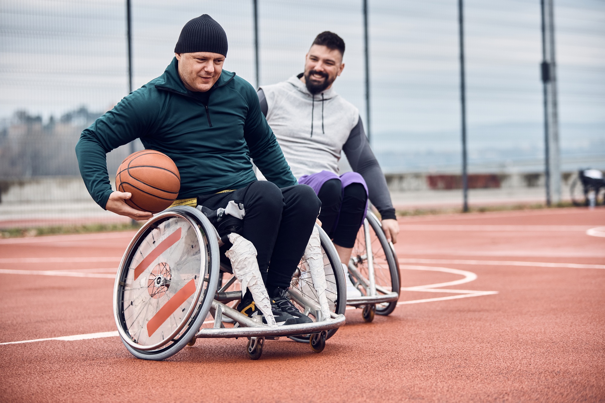 Man in wheelchair playing basketball as part of NDIS life skills training with Caring Humanity